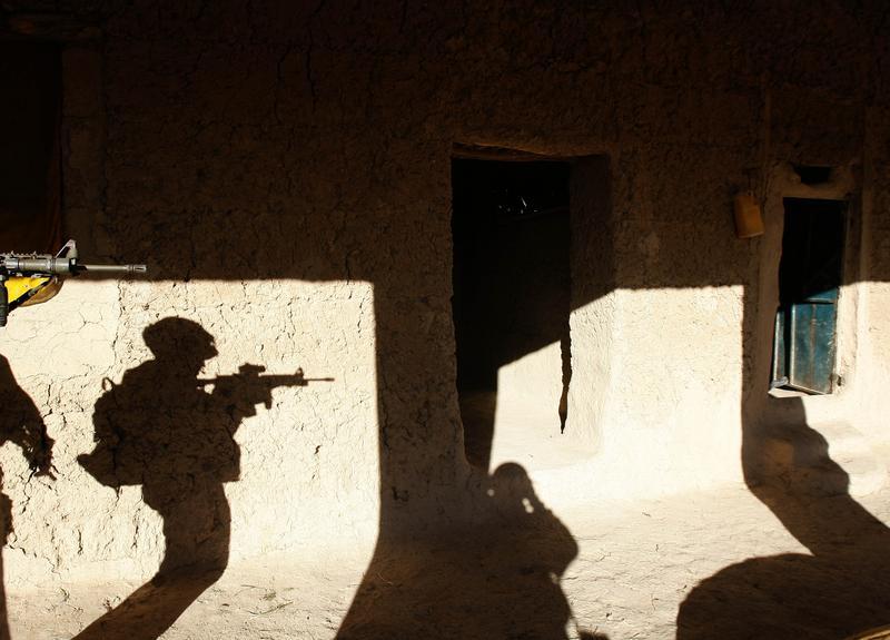 A soldier searches a house in a village in Baluchi pass in Uruzgan province, November 1, 2007.